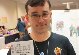 Steven is holding a copy of his F.E.D.s comic and has an example of his clay art.