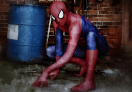 Kyle cosplaying as Spider-Man poses dramatically in a city alley.