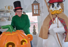 Douglas wears a matching top hat next to a whimsical fantasy snowman. A jack-o-lantern prop is in front of him.