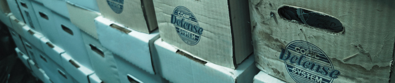 Cardboard comic storage boxes showing signs of age, wear, and water damage.